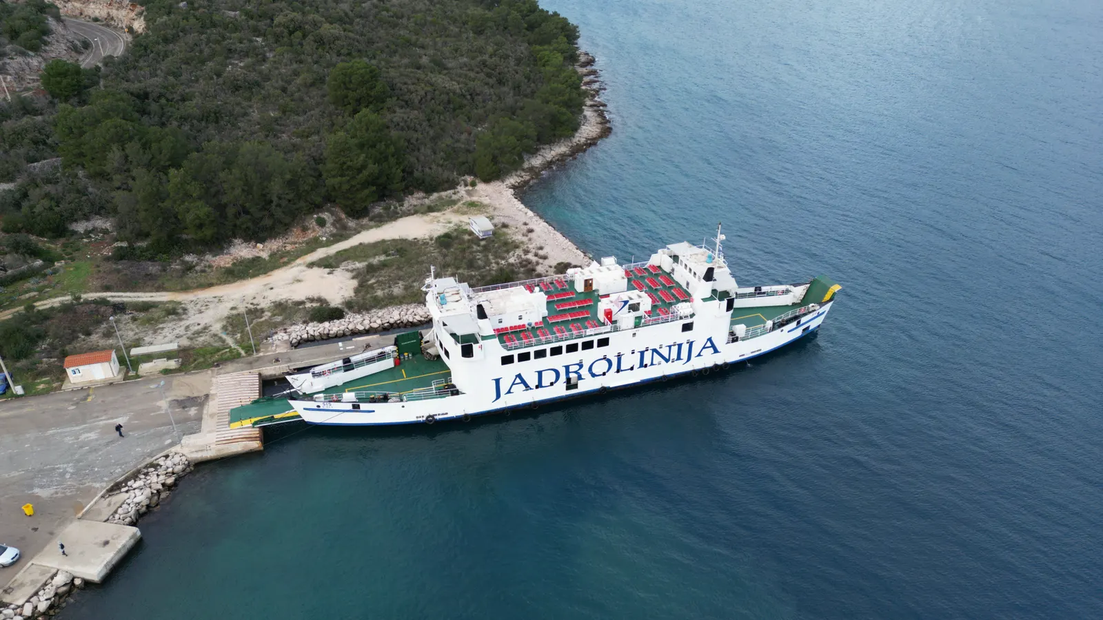 A car ferry berthed in a rocky cove on the Dalmatian coast