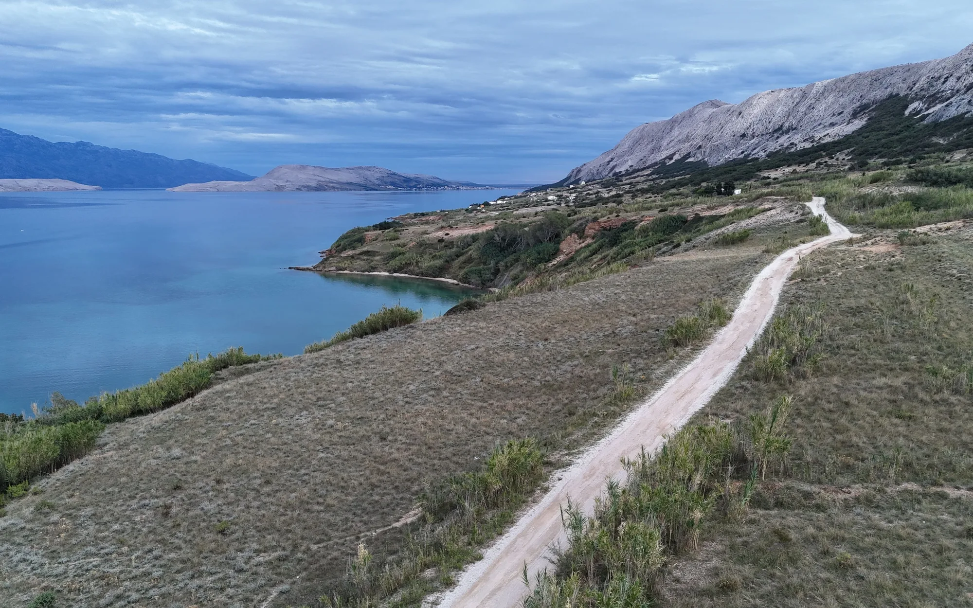 A road running along a bare limestone ridge above the sea