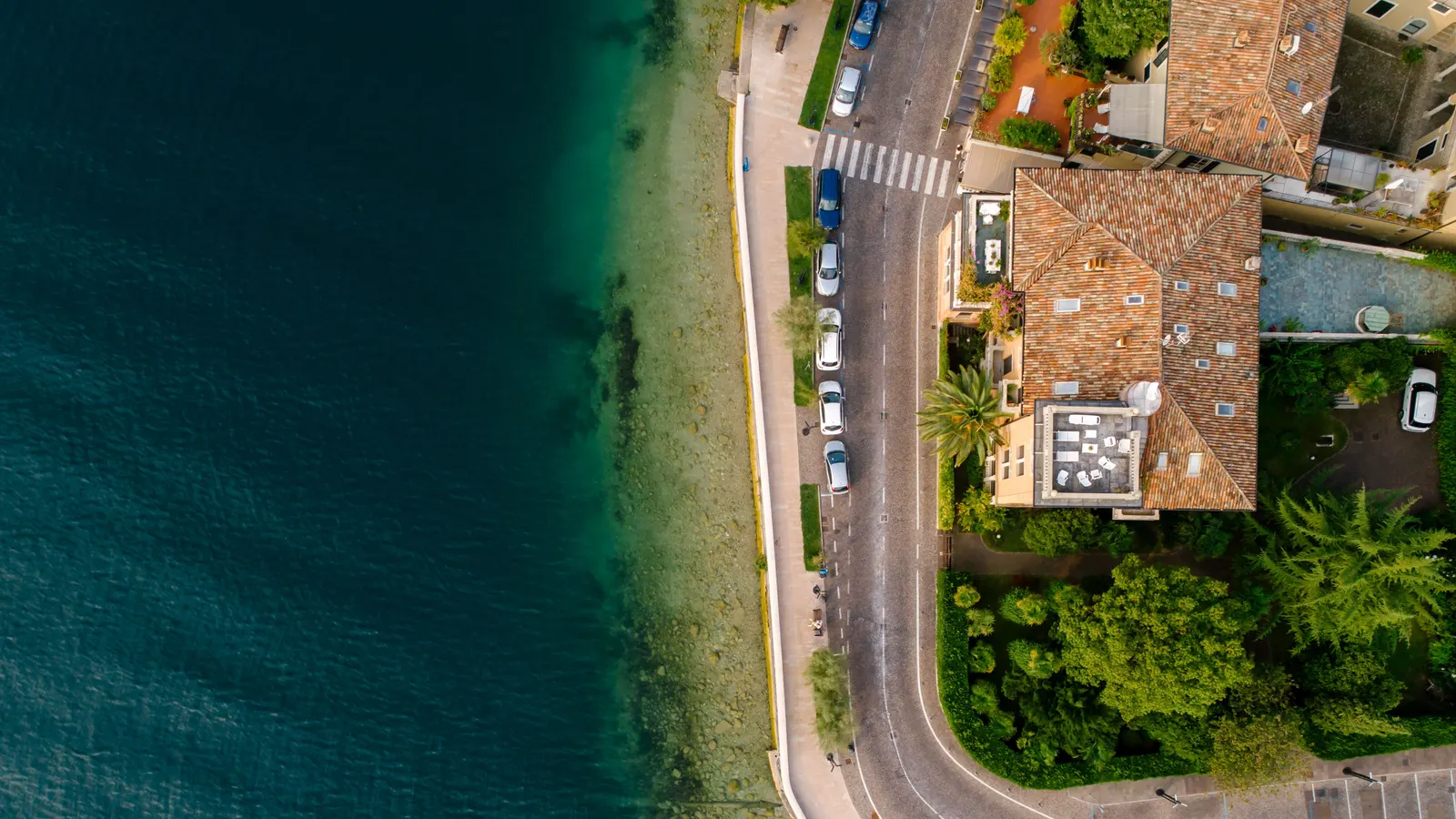 Cars parked along a coastal road above the water